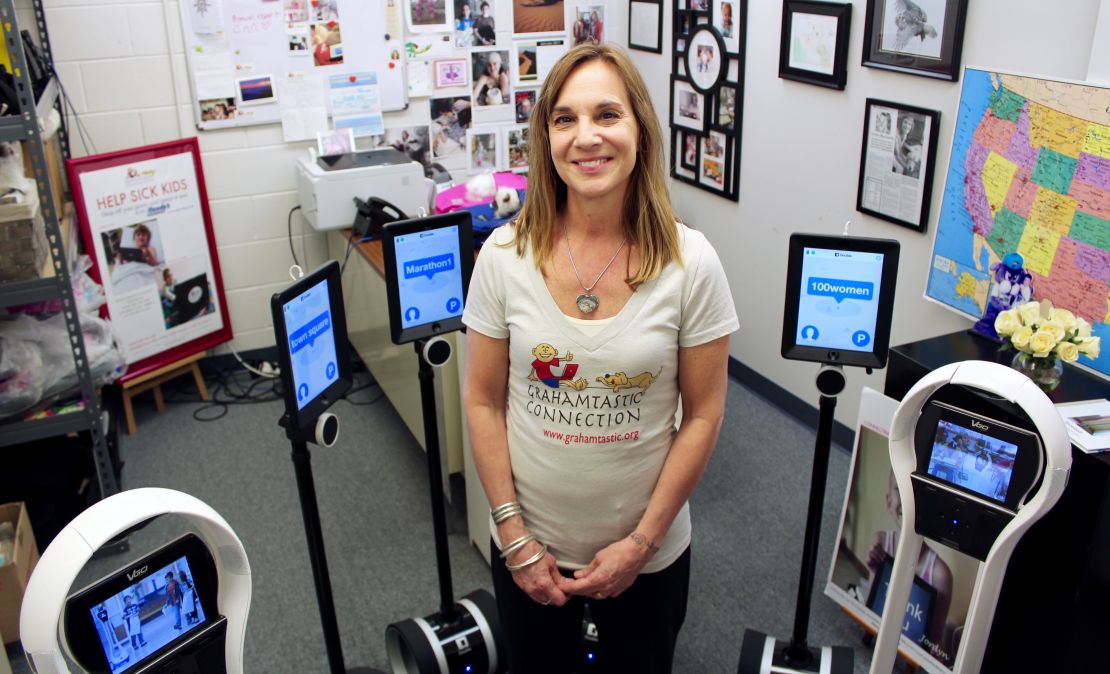 Morissette with robots the nonprofit provides to help kids stay connected to school