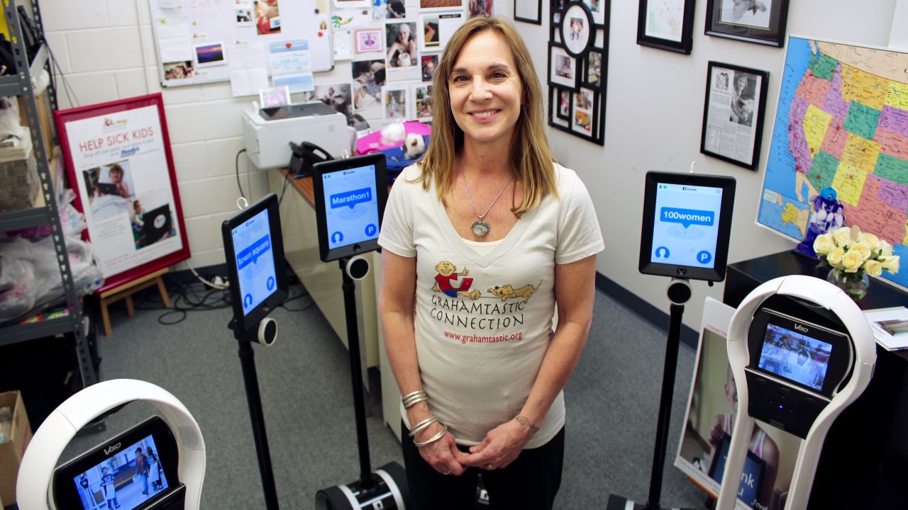 Morissette with robots the nonprofit provides to help kids stay connected to school