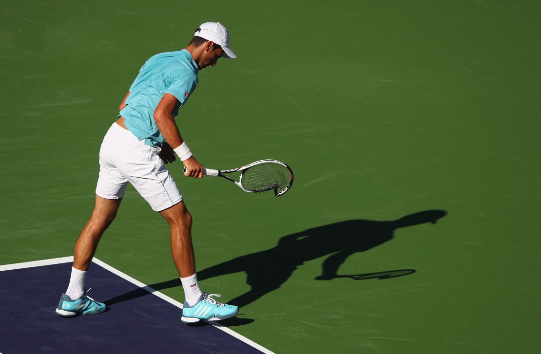 A frustrated Djokovic smashes his racquet on the ground