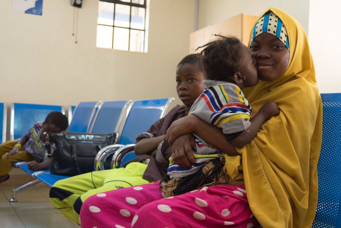 Asha gives her sister Zeinab a kiss while the family waits for medical screenings in Nairobi.