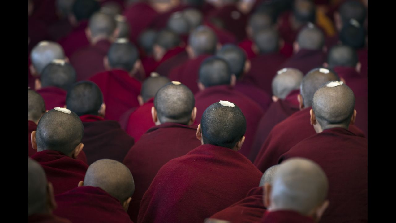 Tibetan monks wear ceremonial seeds on their heads as they listen to the Dalai Lama, their spiritual leader, in Dharamsala, India, on Tuesday, March 14.