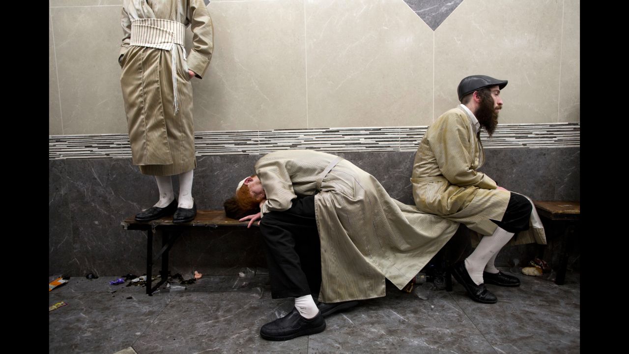 Intoxicated men rest in Jerusalem as they celebrate the Jewish holiday of Purim on Monday, March 13.