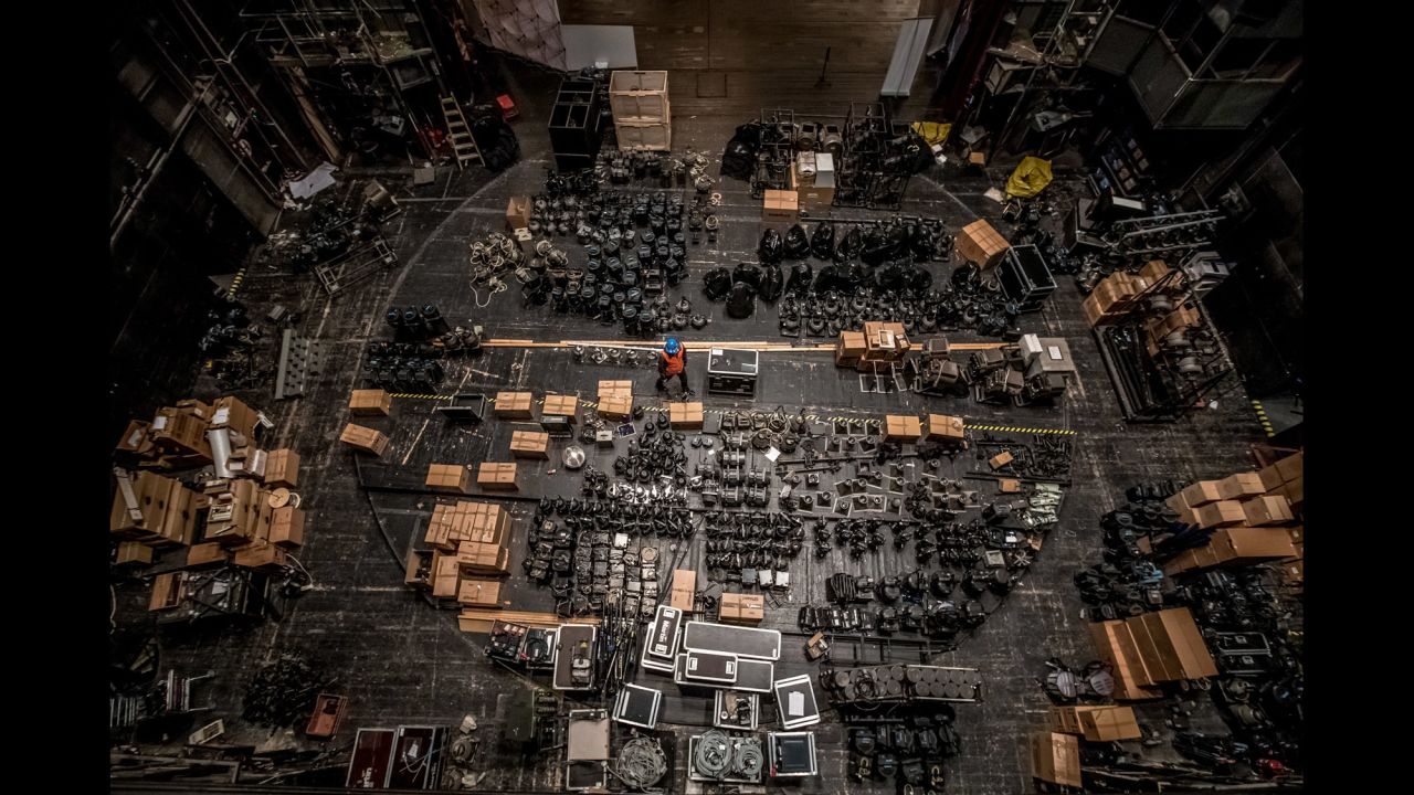 A worker walks between spotlights that were gathered backstage at the State Opera in Prague, Czech Republic, on Sunday, March 13. The building is being reconstructed.