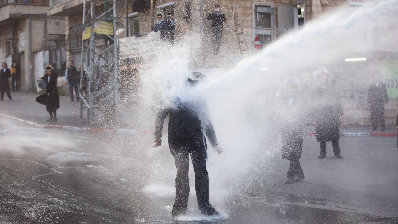 An ultra-Orthodox Jew is hit by a police water cannon during an anti-draft protest in Jerusalem on Wednesday, March 15.