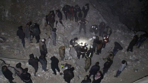 Syria Civil Defense volunteers dig through rubble after a reported airstrike Thursday on al-Jena, Syria.