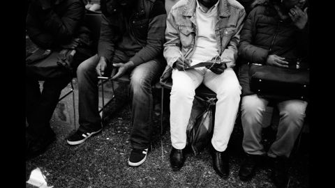 People fill out forms as they wait their turn.