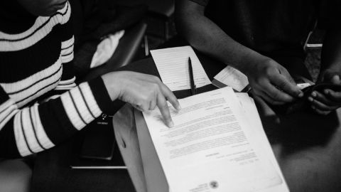 A couple looks through paperwork as they wait to speak with lawyers.