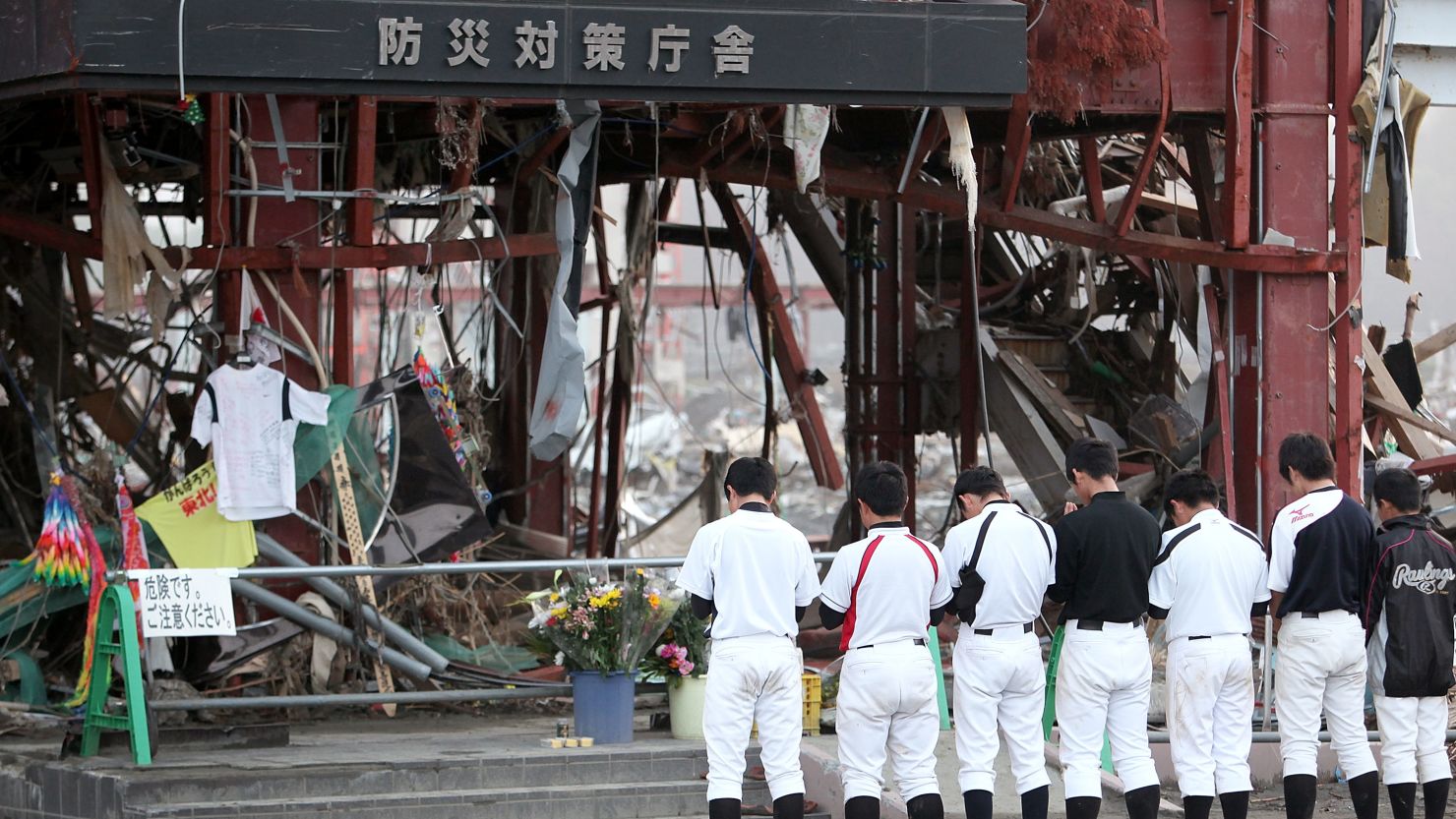 Members of a baseball team pray for their coach who went missing during the Fukushima disaster. 