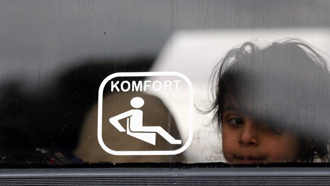 A Syrian girl looks on as she sits on a bus waiting to leave Homs. 
