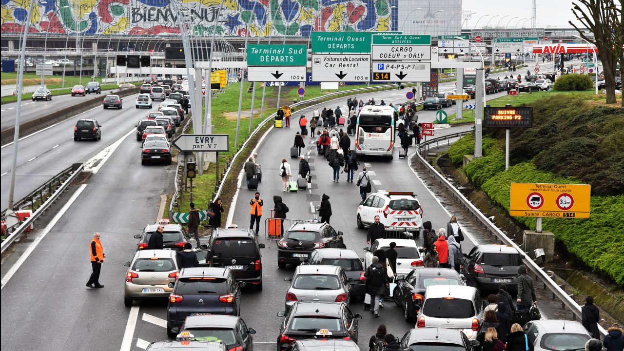 Passengers evacuated from Orly airport walk on the highway.