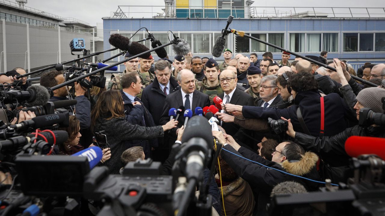 French Interior Minister Bruno Le Roux and French Defense Minister Jean-Yves Le Drian talk with reporters at Orly airport.