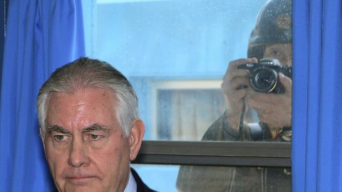 A North Korean soldier, right, tries to take a photograph through a window while US Secretary of State Rex Tillerson visits the DMZ. 