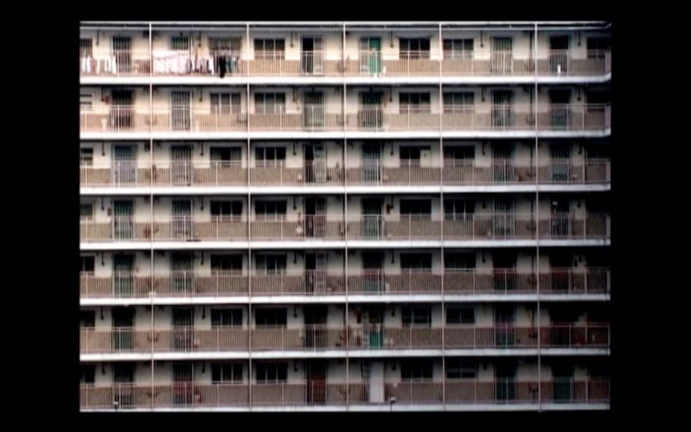 Artist Chilai Howard, a public housing resident, documented the opening and closing doors and windows in one of the first housing estates in Hong Kong, Nam Shan Estate, and remixed the recording into a choreography of vertical living. 