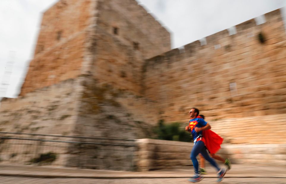 A competitor dressed as Superman runs along the Old City ramparts.