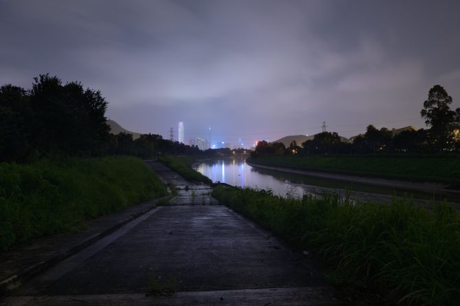 Artist Siu Wai Hang's "Inside Outland" tries to reimagine his father's swim from mainland China to Hong Kong as a refugee in the 1970s. In a silent film, Siu dives into the waves with a camera at night, the grainy footage recording an emotional more than physical landscape. Still photographs including this one, taken by a small creek in Hong Kong looking across the border to Shenzhen's shining new skyline, seem to reverse the journey.