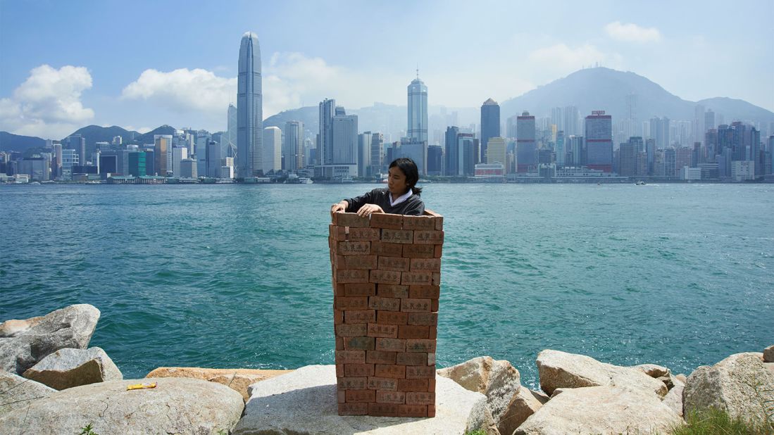 In this iconic performance artist South Ho stands before a sparkling Victoria Harbour while building a phone booth-sized wall around himself, brick by brick. As curator Chan notes, "There have been lots of voices saying we should keep the mainland Chinese away from Hong Kong, but what if we really do that? By building walls around you, you might have trapped yourself inside too."<br />