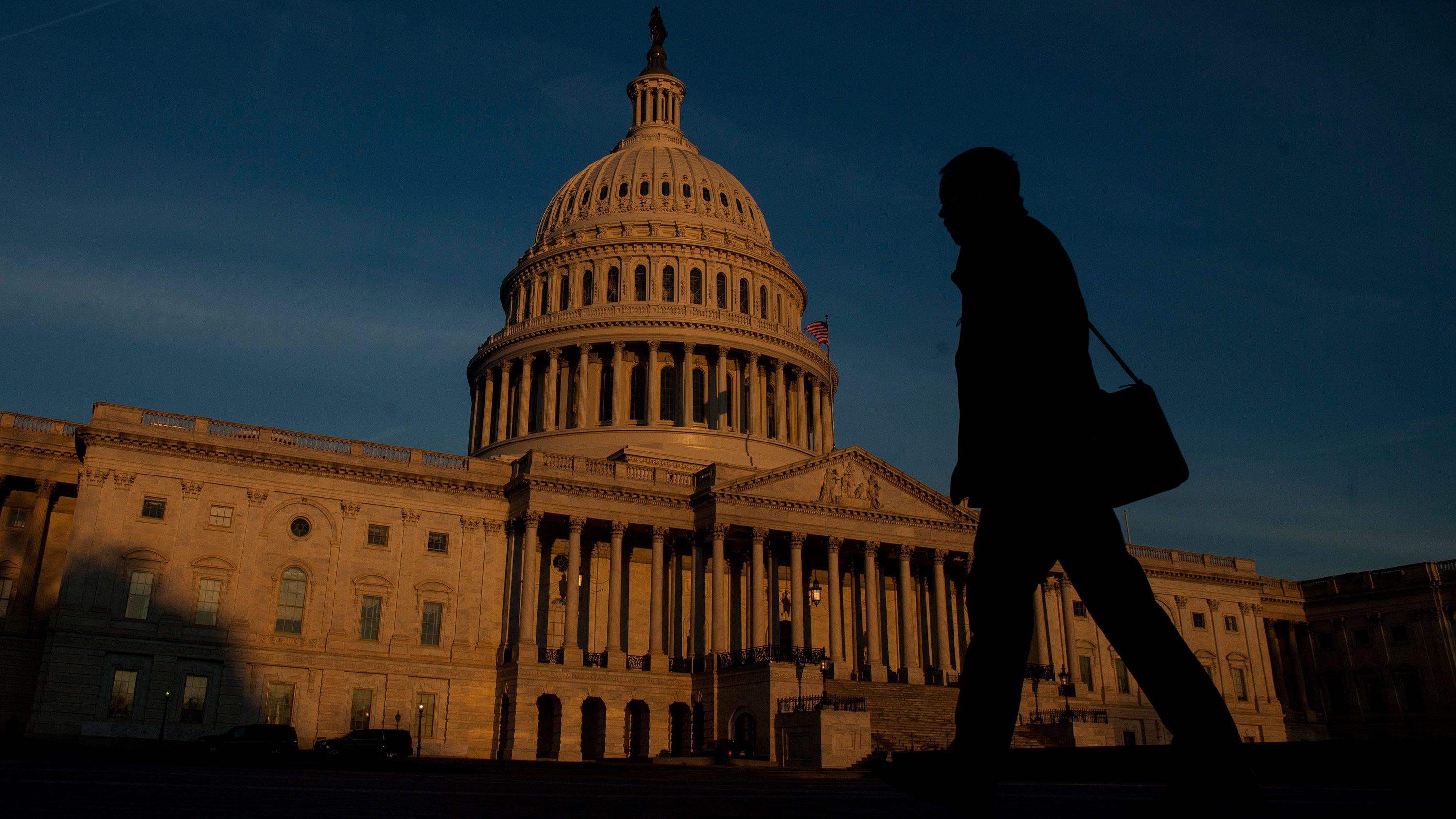 WASHINGTON, D.C. - MARCH 20:  A person walks by as the sun rises near The United States Capitol Building on March 20, 2017 in Washington, D.C. (Photo by Zach Gibson/Getty Images)