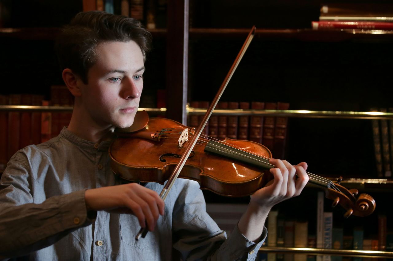 Guildhall School of Music and Drama student Samuel Staples poses with the "ExCroall; McEwen" violin made by Antonio Stradivari in 1684.