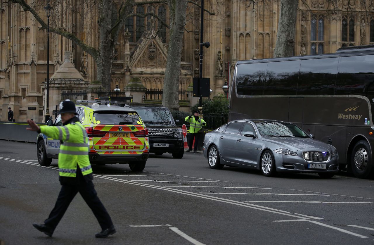 At right, the car of British Prime Minister Theresa May is driven away from Parliament.
