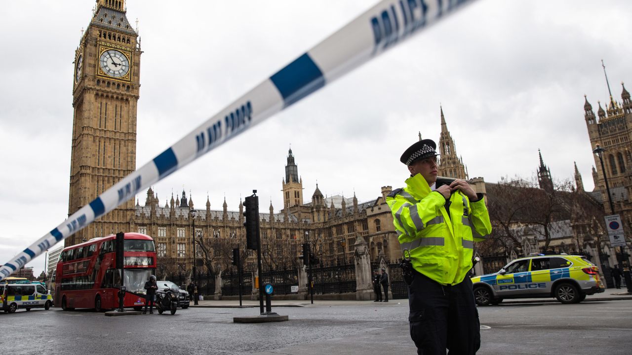 A police officer stands guard near Westminster Bridge and the Houses of Parliament.