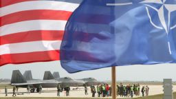 The US and The NATO flag fly in front of two US Air Force F-22 Raptor fighter aircraft at the Air Base of the Lithuanian Armed Forces in Siauliai, Lithuania, on April 27, 2016.  