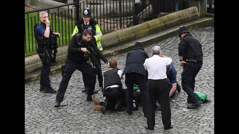 An armed police officer stands over the attacker, identified as Khalid Masood, outside Parliament. "It appeared that a car was coming towards the House of Commons mowing down pedestrians on the way," Member of Parliament Gerald Howarth told CNN. "The driver then got access to the parliamentary estate, stabbed a police officer and was shot."