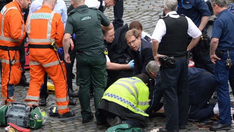 Member of Parliament Tobias Ellwood, in the glasses, <a href="index.php?page=&url=http%3A%2F%2Fedition.cnn.com%2F2017%2F03%2F22%2Fworld%2Ftobias-ellwood-london-rescue%2Findex.html" target="_blank">tends to one of the injured people</a> amid the chaos. The man the politician was trying to save was a police officer who died, a witness on the scene told CNN. Authorities identified the deceased officer as Keith Palmer, 48.