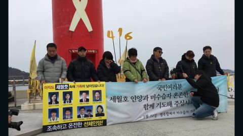 Family members of Sewol ferry victims gather in front of a lighthouse near the site of the sunken vessel.