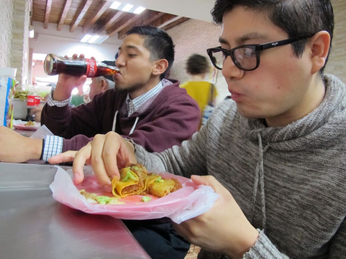 Matadamas, left, and his cousin, Daniel Velasco,  eating at a taco stand.                            