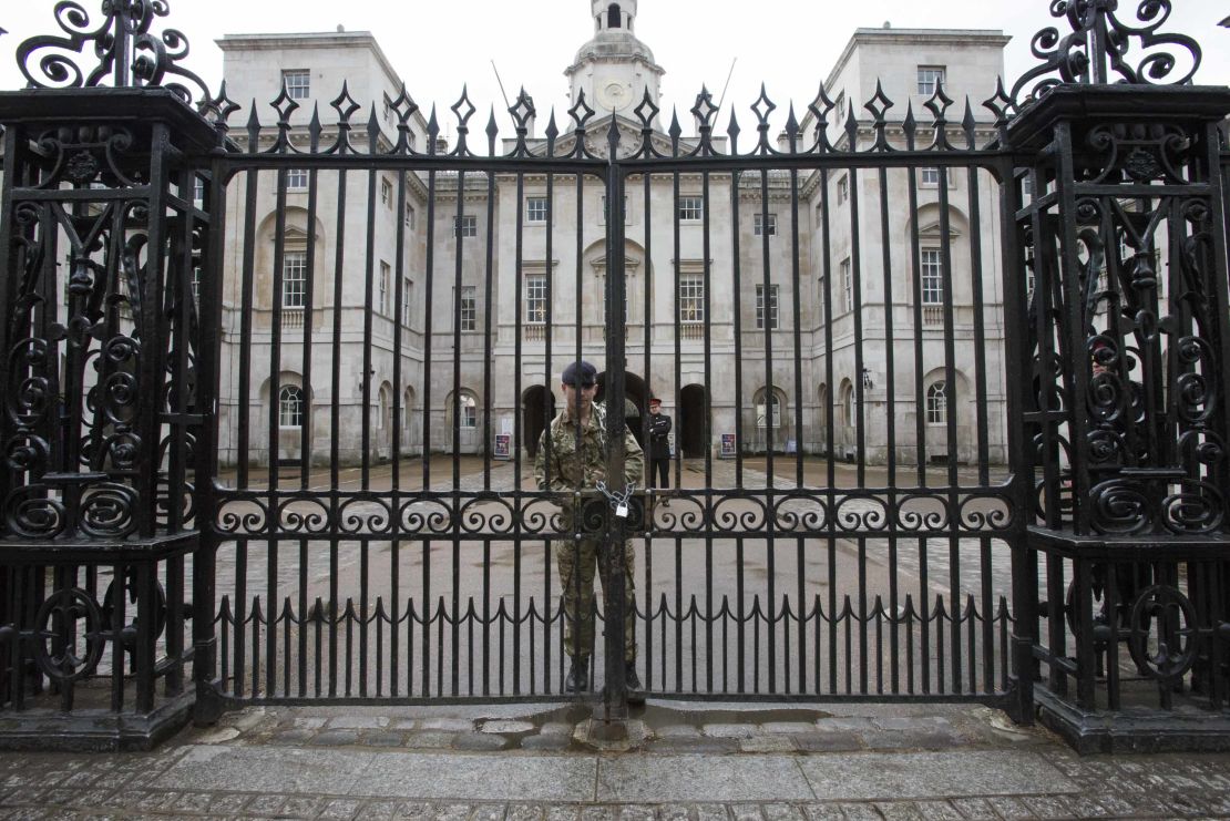 A soldier chains the gate at Horse Guards after Wednesday's terror attack. The entrances to Downing Street and Buckingham Palace were also closed as precautions.