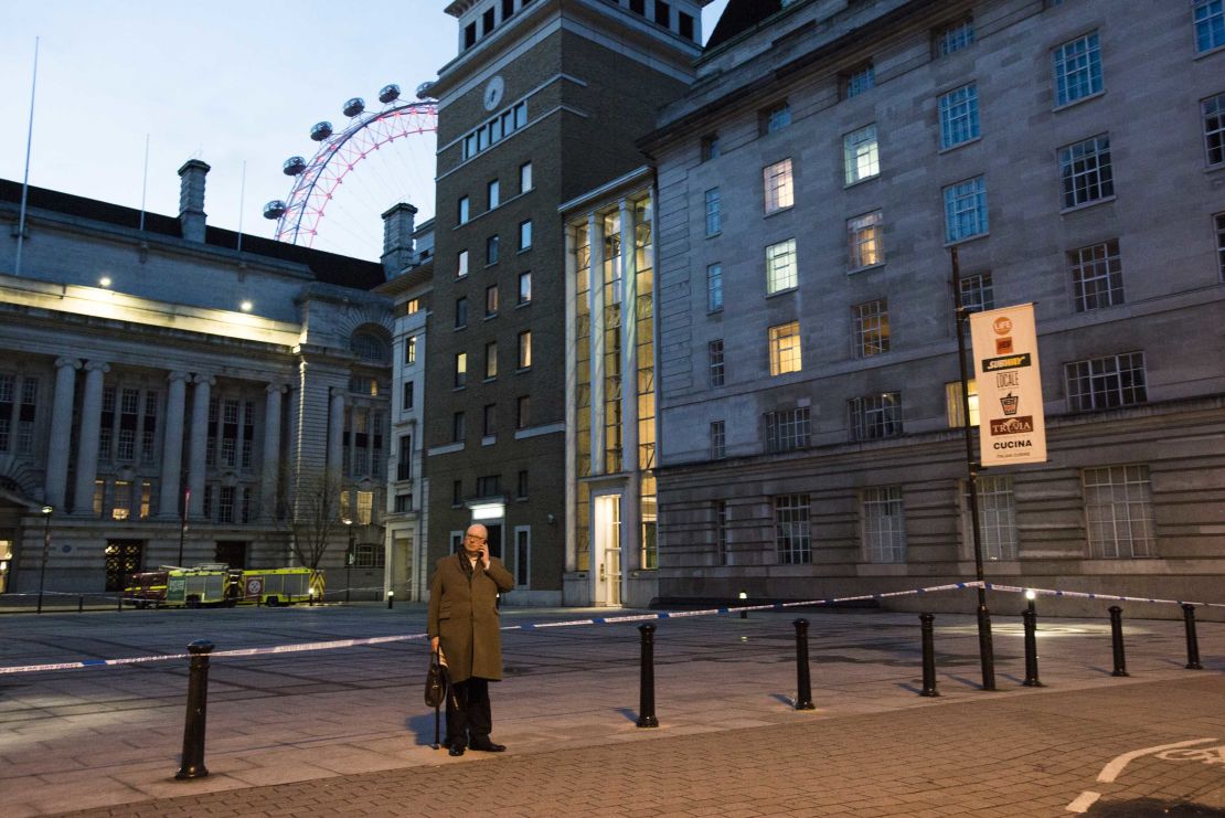 A man talks on a cellphone near the London Eye, where tourists were held on the sightseeing attraction during the incident.