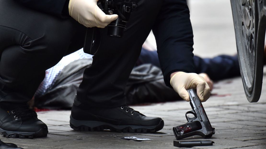 A Ukrainian police officer seizes a gun at the scene  Voronenkov's killing Thursday in Kiev.