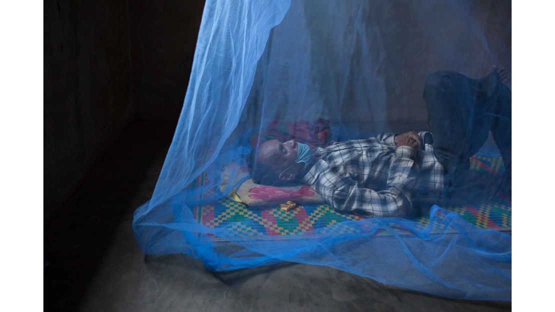 Sam Mowum, 71, takes a nap inside his home in Proy village in Mamot district, Cambodia. To avoid infecting his family, Sam Moeum left the family home to complete his treatment and now lives alone. 