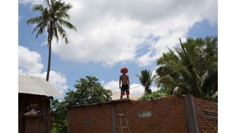 Pham Anyang, a TB patient from Srosomthmy village, completes building work on the roof his home.
