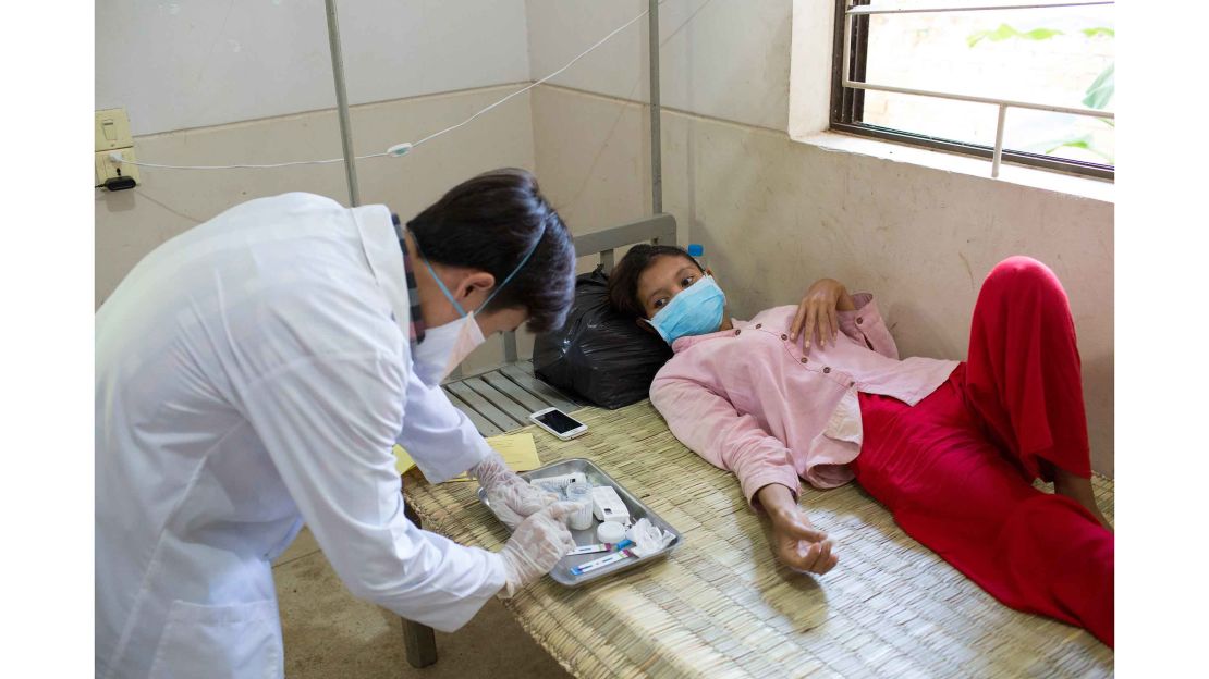 A nurse administers TB treatment to Tram Saram, 23, at Kampong Cham District Hospital. She had a three-hour journey to the hospital and her family was unable to be with her.