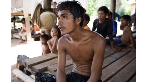 Pham Anyang, 28, stops for a portrait outside his home in Srosomthmy village, in Mamot district, Cambodia.  He is completing his TB treatment at home with the support of RHAC, a local NGO. 