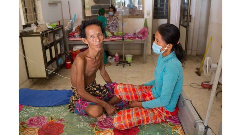 Meas Mao, 48, sits next to her husband on the TB ward at Kampong Cham District Hospital. He has TB meningitis.