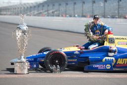 Alexander Rossi poses with the giant Borg-Warner Trophy after winning the 2016 Indy 500.