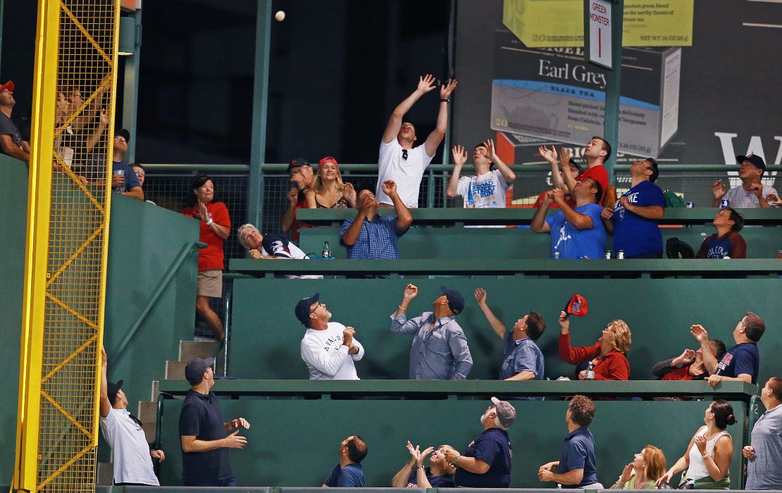 Fans in coveted Green Monster seats vying for a ball hit by Boston Red Sox player Mookie Betts during a practice session in 2016.