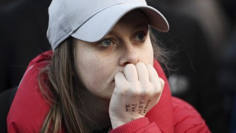 A woman looks on during the vigil. A message written on her hand reads: "We are not afraid"