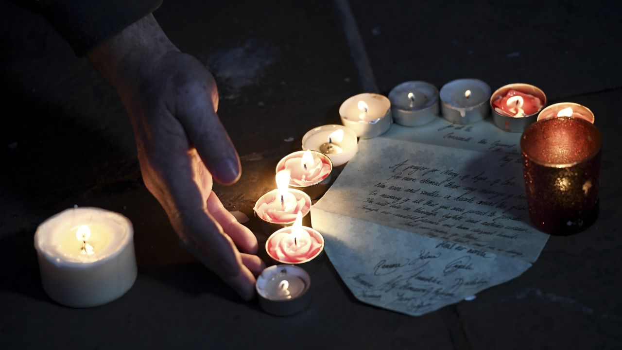 A letter is left among votive candles during the vigil.