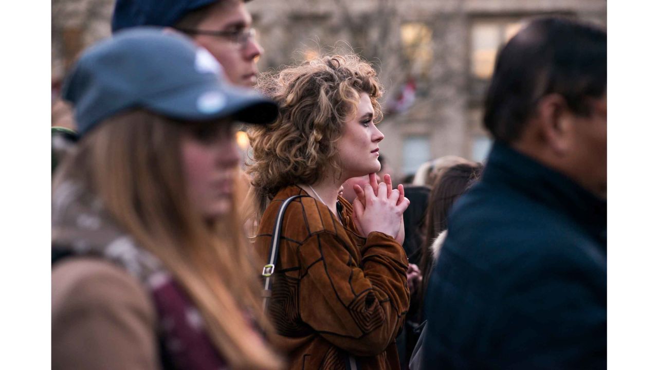 Kit Keane, 19, an American student at King's College London, clasps her hands as the vigil begins.