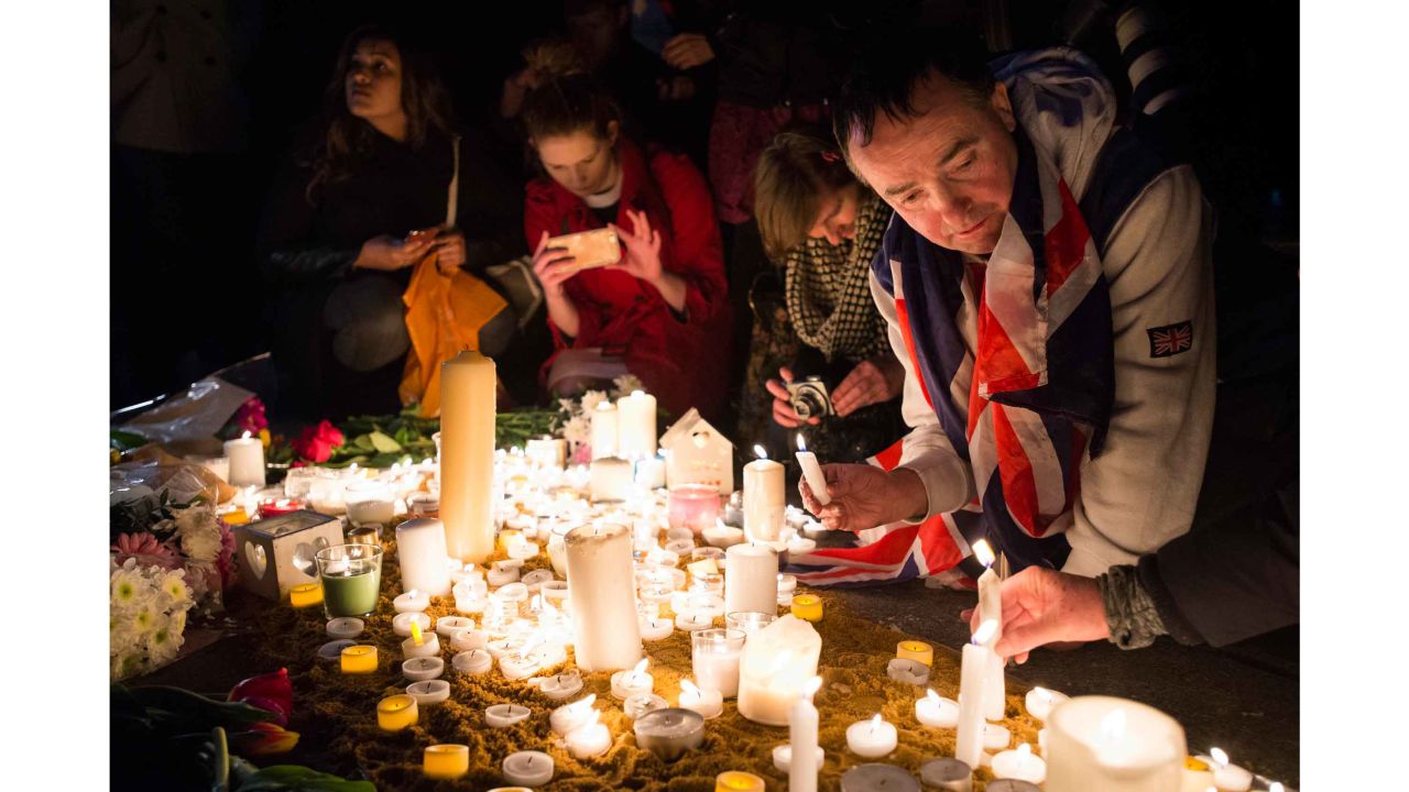John Loughrey tends to candles in Trafalgar Square.