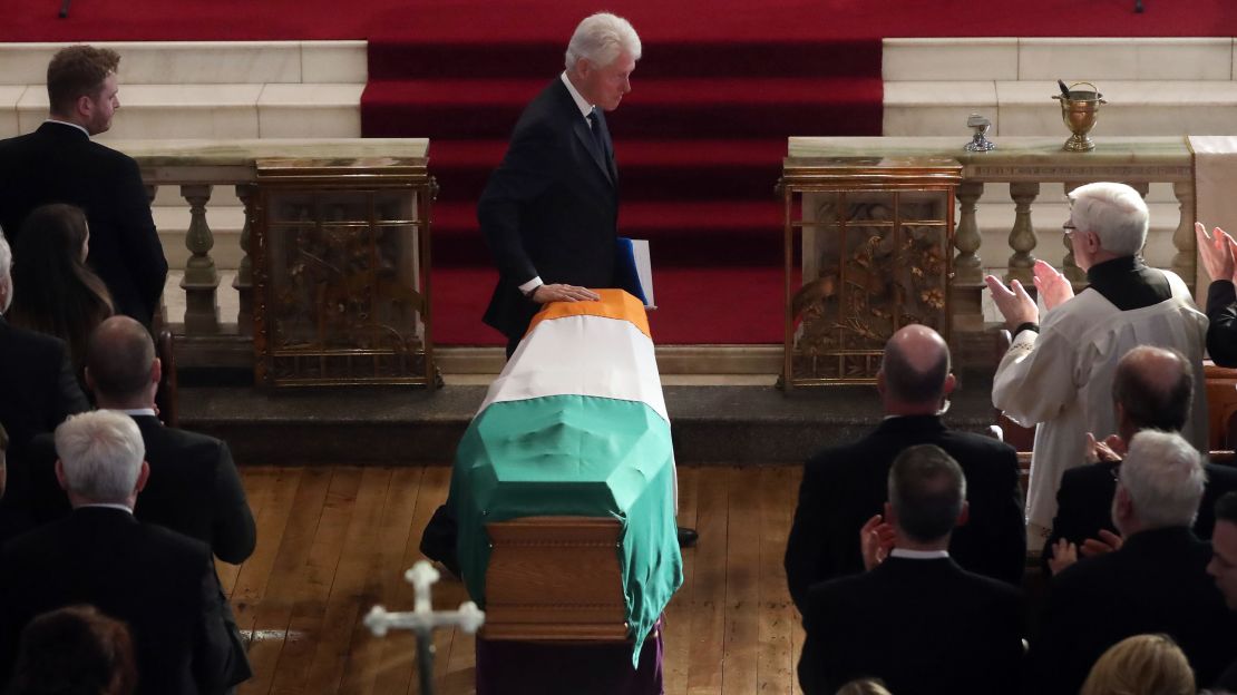 Former US President Bill Clinton touches the coffin Thursday of Martin McGuinness, the Northern Ireland politician and one-time IRA commander
