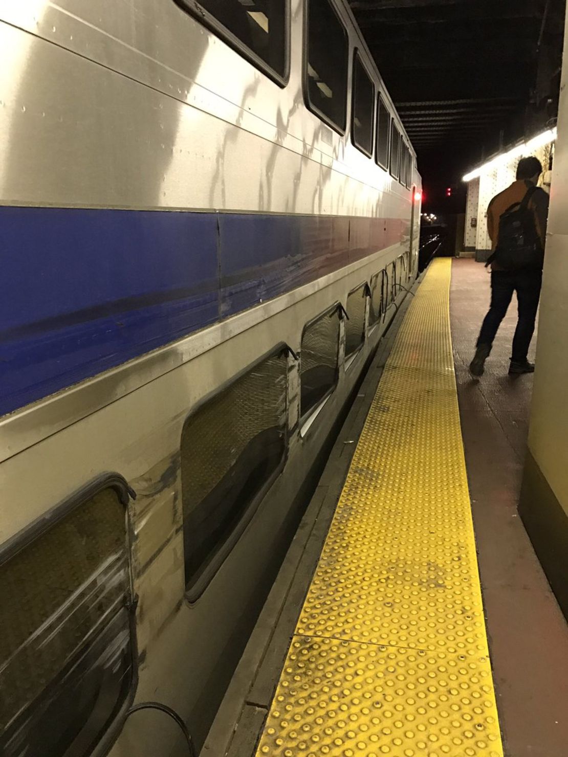 The side of an NJ Transit train was scraped by a derailed Amtrak train.