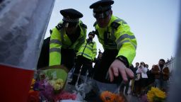 Police officers lay flowers in honour of the victims of the March 22 terror attack at the end of Westminster Bridge by the Houses of Parliament in central London on March 23, 2017 after the bridge reopened. 
Britain's parliament reopened on Thursday with a minute's silence in a gesture of defiance a day after an attacker sowed terror in the heart of Westminster, killing three people before being shot dead. Sombre-looking lawmakers in a packed House of Commons chamber bowed their heads and police officers also marked the silence standing outside the headquarters of London's Metropolitan Police nearby.
 / AFP PHOTO / Daniel LEAL-OLIVAS        (Photo credit should read DANIEL LEAL-OLIVAS/AFP/Getty Images)