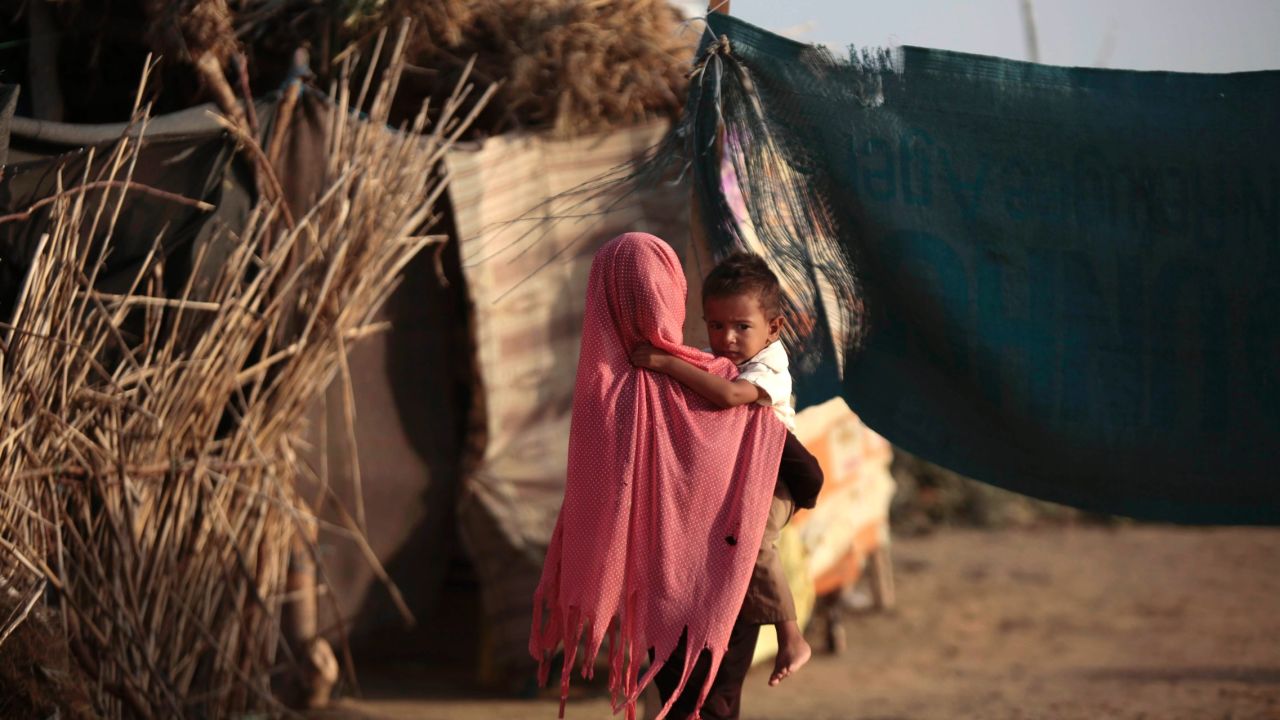 A displaced girl holds her brother at a camp for internally displaced people near the town of Abs, located on Yemen's western coastal plain.