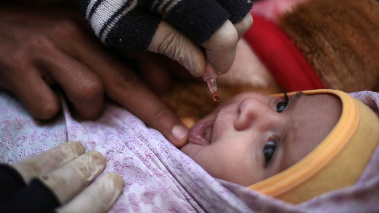 An infant receives a polio vaccination during a house-to-house polio immunization campaign in Sanaa.