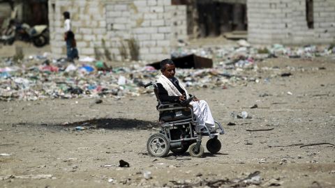 A Yemeni man in a wheelchair makes his way at a slum in Sanaa.