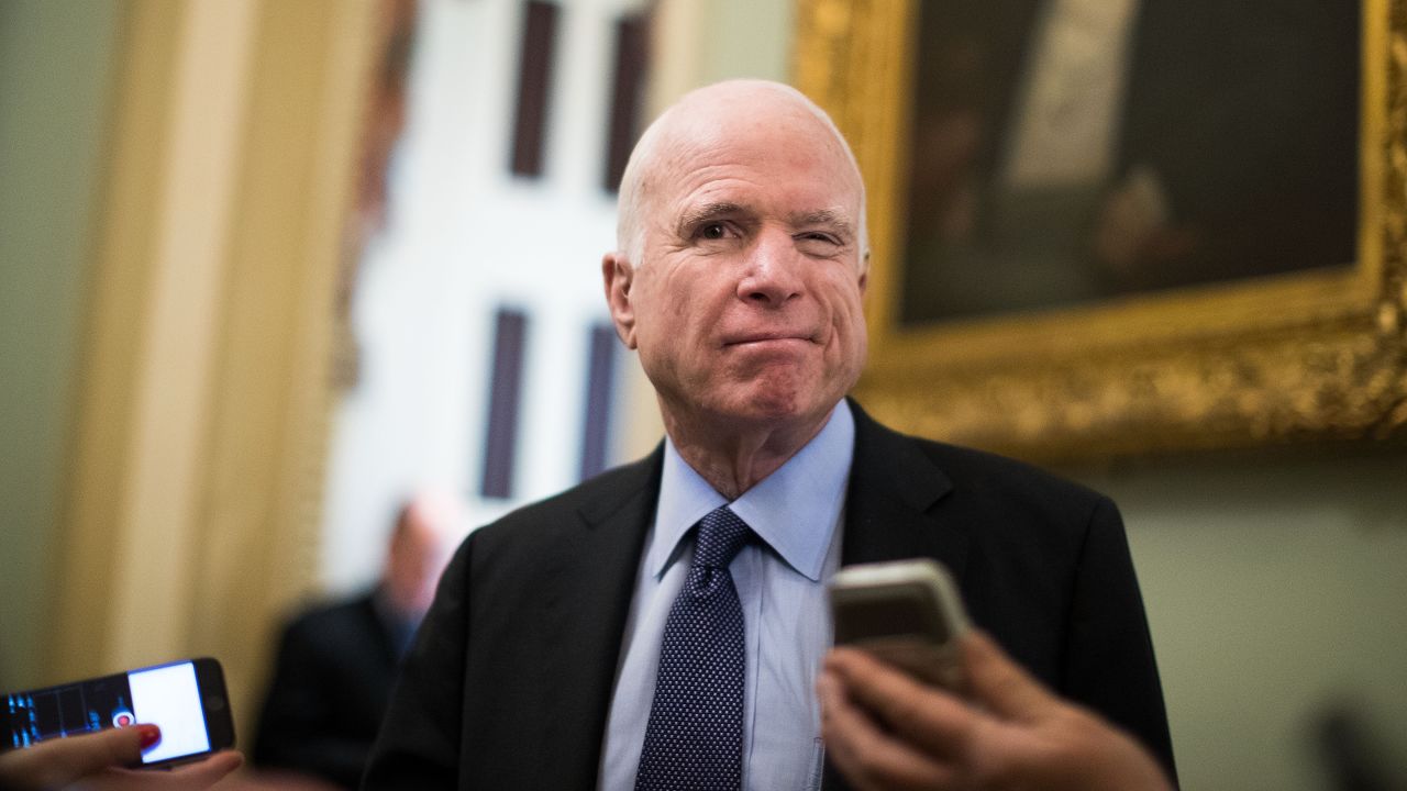 Sen. John McCain winks as he speaks with reporters outside of the Senate chamber on Capitol Hill on Thursday, March 23.